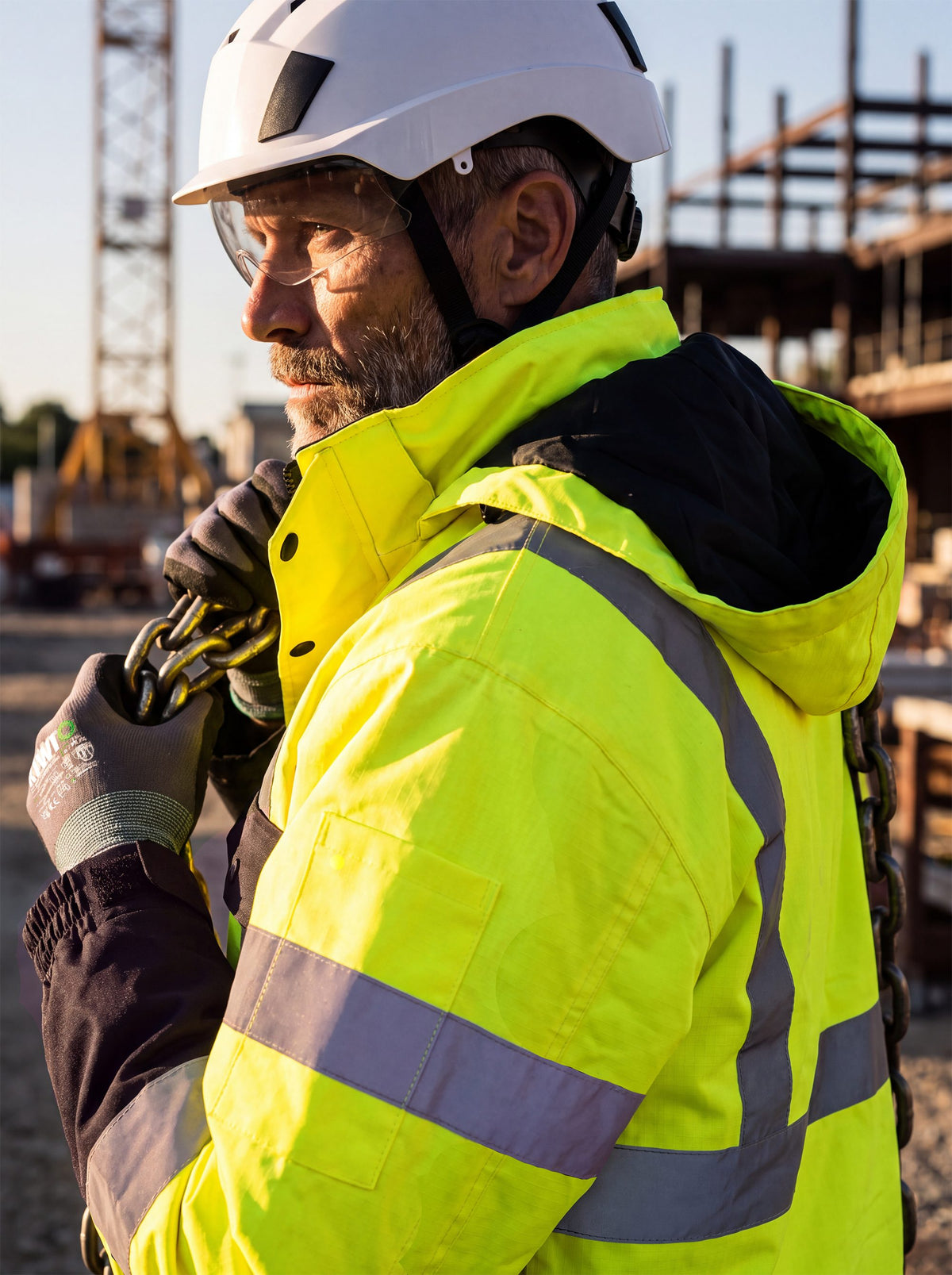 Worker in a Kiwi hi-vis safety jacket and hard hat on a jobsite